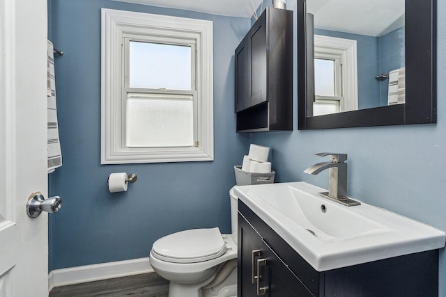 bathroom with wood-type flooring, toilet, and vanity