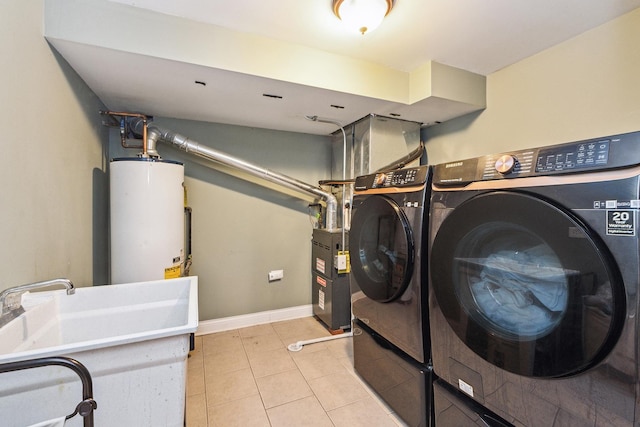 clothes washing area featuring separate washer and dryer, light tile patterned floors, and gas water heater