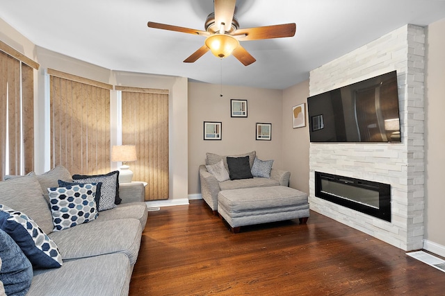 living room with a fireplace, dark hardwood / wood-style floors, and ceiling fan