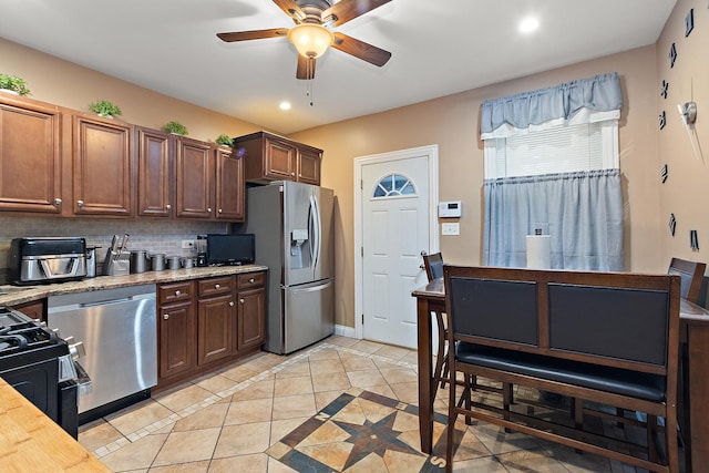 kitchen featuring ceiling fan, appliances with stainless steel finishes, decorative backsplash, and light tile patterned floors