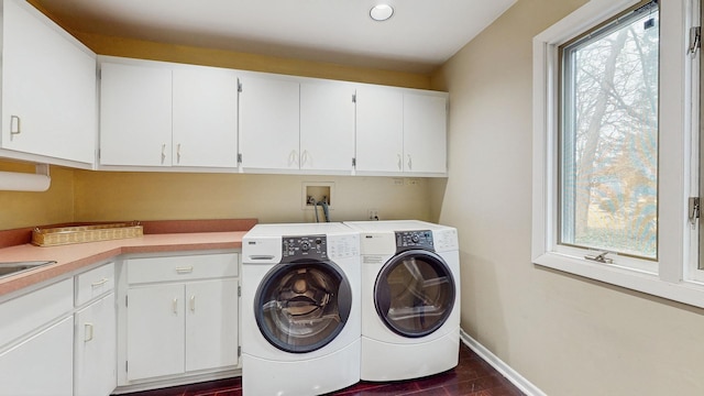 laundry area with dark hardwood / wood-style flooring, washing machine and dryer, and cabinets