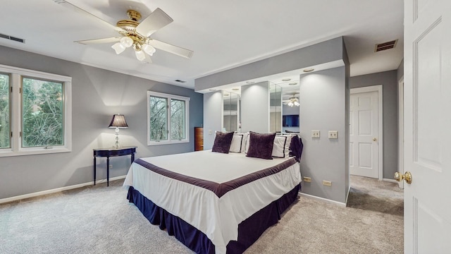 bedroom featuring multiple windows, light colored carpet, and ceiling fan