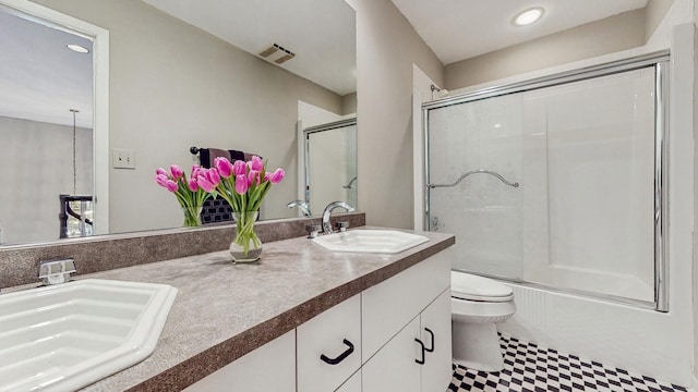 full bathroom with bath / shower combo with glass door, vanity, and toilet