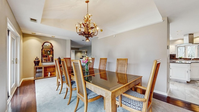 dining space featuring sink, a notable chandelier, and dark hardwood / wood-style flooring