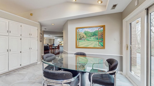 dining space featuring vaulted ceiling