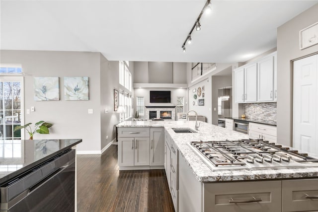 kitchen featuring beverage cooler, a spacious island, open floor plan, stainless steel gas stovetop, and a sink