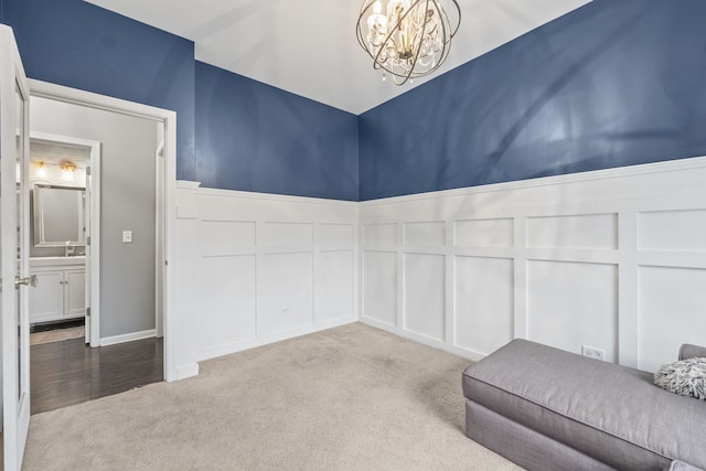 interior space with a notable chandelier, carpet, and a decorative wall