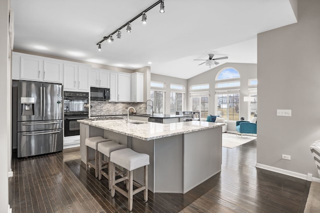 kitchen with dark wood-style floors, lofted ceiling, backsplash, and black appliances