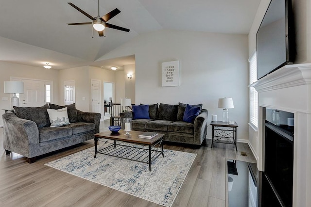 living room featuring wood-type flooring, lofted ceiling, and ceiling fan