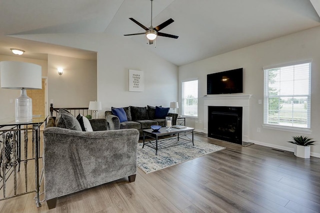 living room with lofted ceiling, wood-type flooring, and ceiling fan