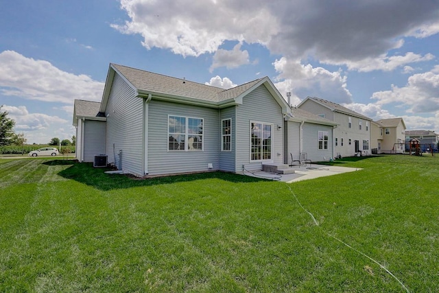 back of house with cooling unit, a lawn, and a patio area