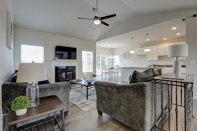 living room featuring ceiling fan, lofted ceiling, and light hardwood / wood-style floors