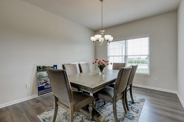 dining space with an inviting chandelier and dark hardwood / wood-style floors