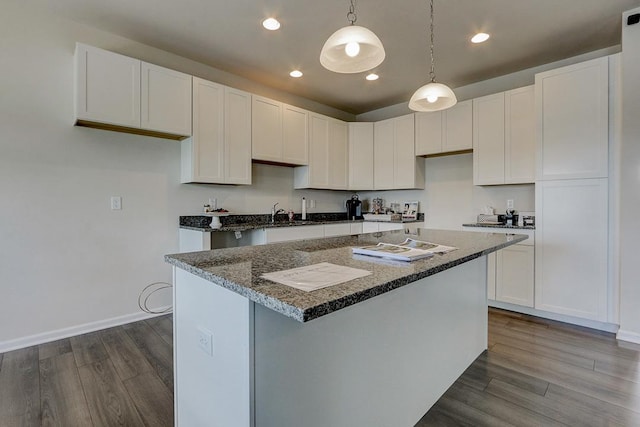 kitchen with wood-type flooring, hanging light fixtures, and white cabinets