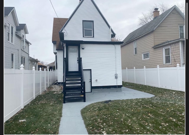 rear view of property featuring a patio area and a lawn