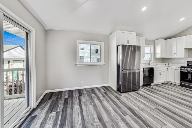 kitchen featuring white cabinetry, sink, stainless steel appliances, and hardwood / wood-style floors