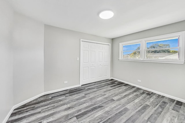 unfurnished bedroom with wood-type flooring and a closet