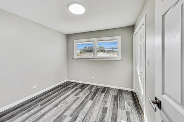 unfurnished bedroom featuring dark wood-type flooring and a closet