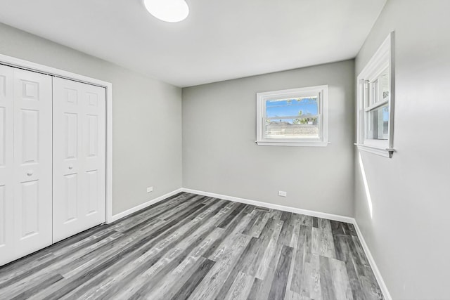 unfurnished bedroom featuring hardwood / wood-style flooring and a closet