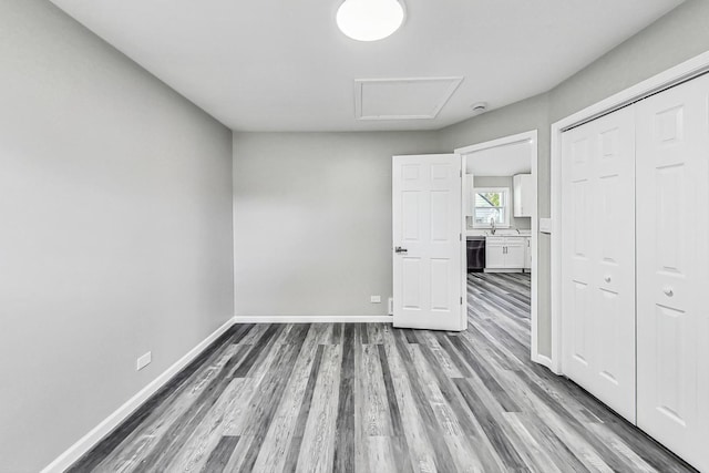 unfurnished bedroom featuring sink, hardwood / wood-style floors, and a closet