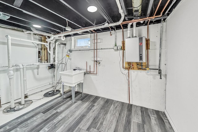 basement featuring hardwood / wood-style flooring and water heater