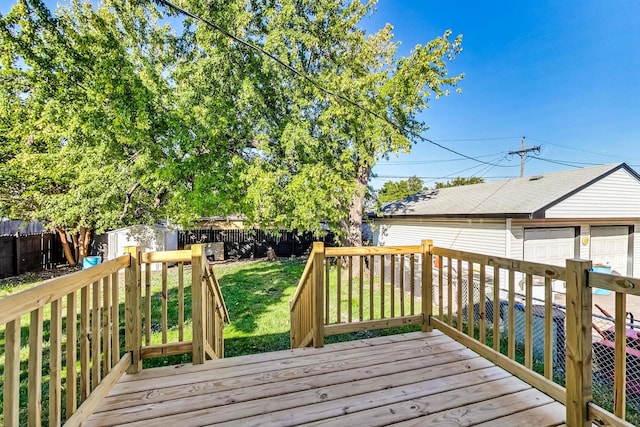 wooden deck featuring a storage unit and a lawn