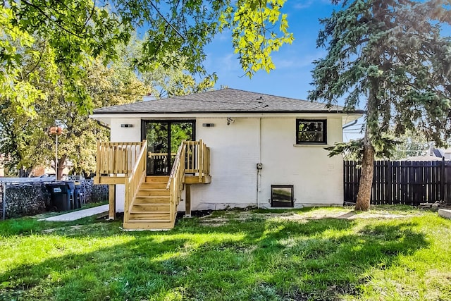 back of house with a wooden deck and a lawn