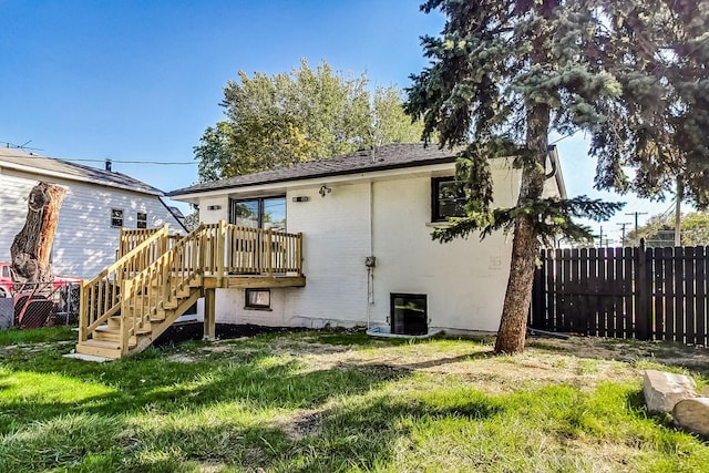 rear view of house featuring a yard and a deck