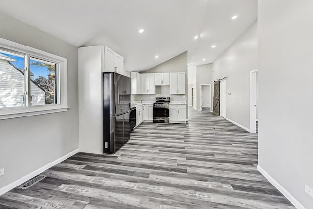 kitchen with white cabinetry, a barn door, light hardwood / wood-style floors, and black appliances