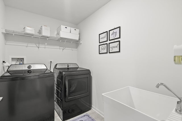 clothes washing area with washing machine and dryer and sink