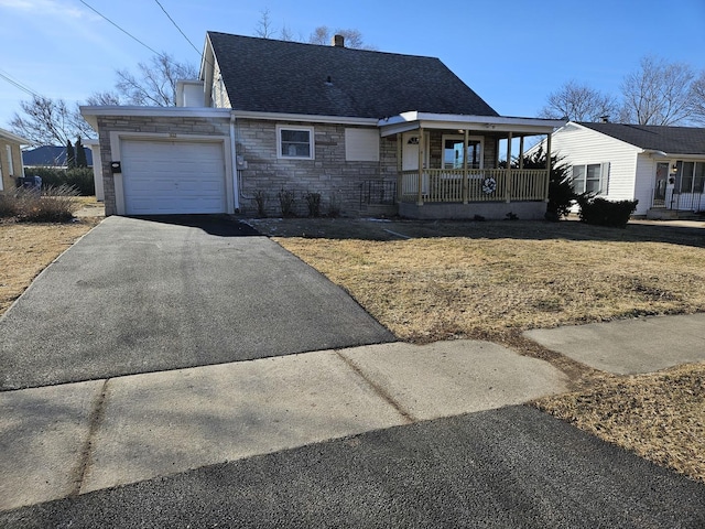 view of front of property featuring a porch, a garage, and a front yard