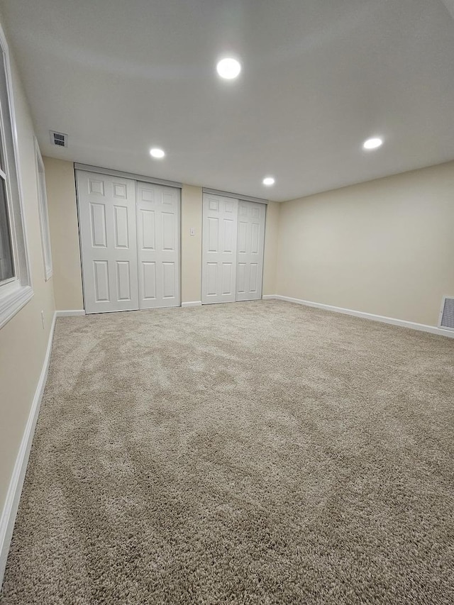 unfurnished bedroom with carpet floors and multiple closets