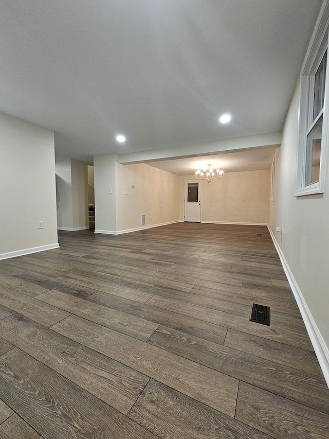 interior space with dark wood-type flooring and a chandelier