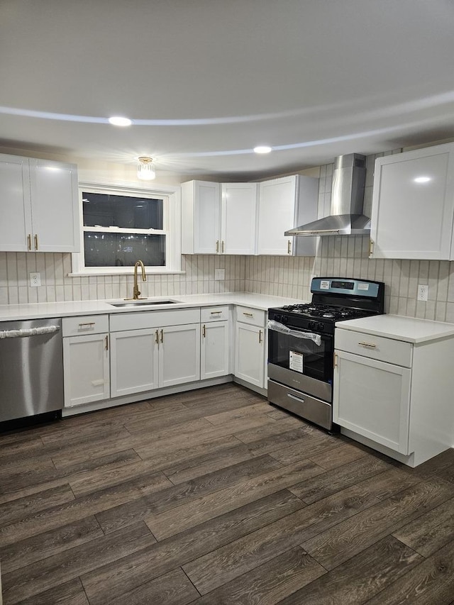 kitchen featuring sink, white cabinets, stainless steel appliances, dark wood-type flooring, and wall chimney exhaust hood