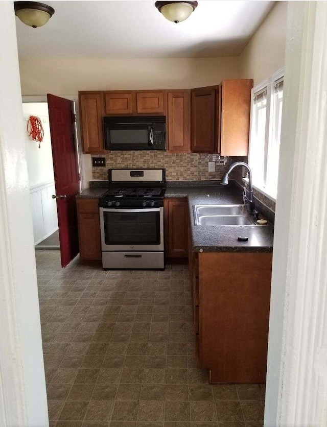 kitchen featuring sink, stainless steel range with gas stovetop, and decorative backsplash