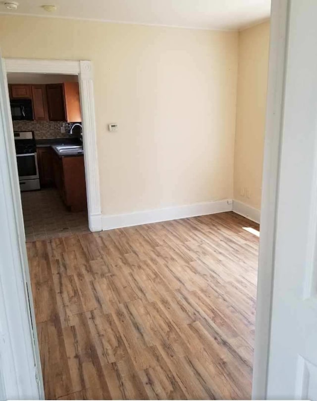 spare room featuring sink and light wood-type flooring