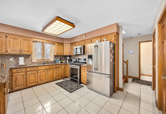 kitchen featuring light tile patterned flooring, sink, dark stone countertops, decorative backsplash, and stainless steel appliances