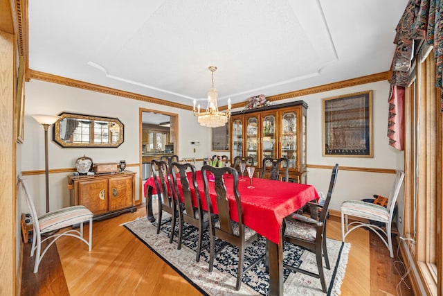 dining area featuring ornamental molding, a chandelier, and light hardwood / wood-style floors