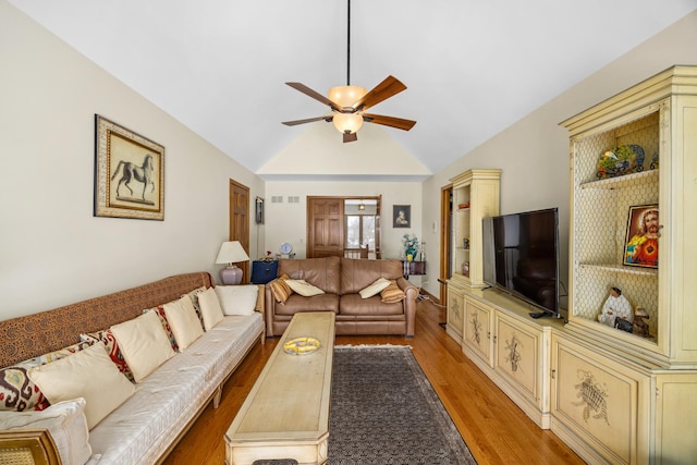 living room with ceiling fan, vaulted ceiling, and light hardwood / wood-style floors