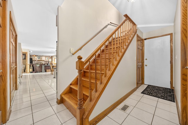 stairs featuring tile patterned floors and ceiling fan