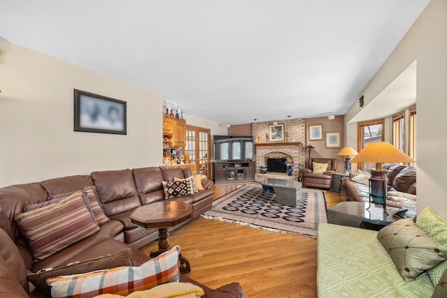 living room with plenty of natural light, hardwood / wood-style floors, and a brick fireplace