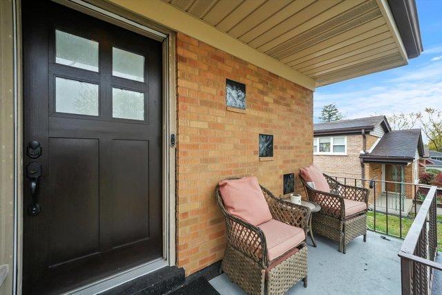 doorway to property featuring a balcony and brick siding