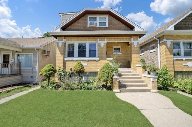 view of front facade featuring a wall mounted AC and a front lawn