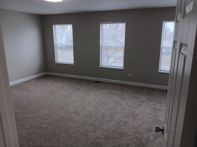 unfurnished room with a healthy amount of sunlight and carpet