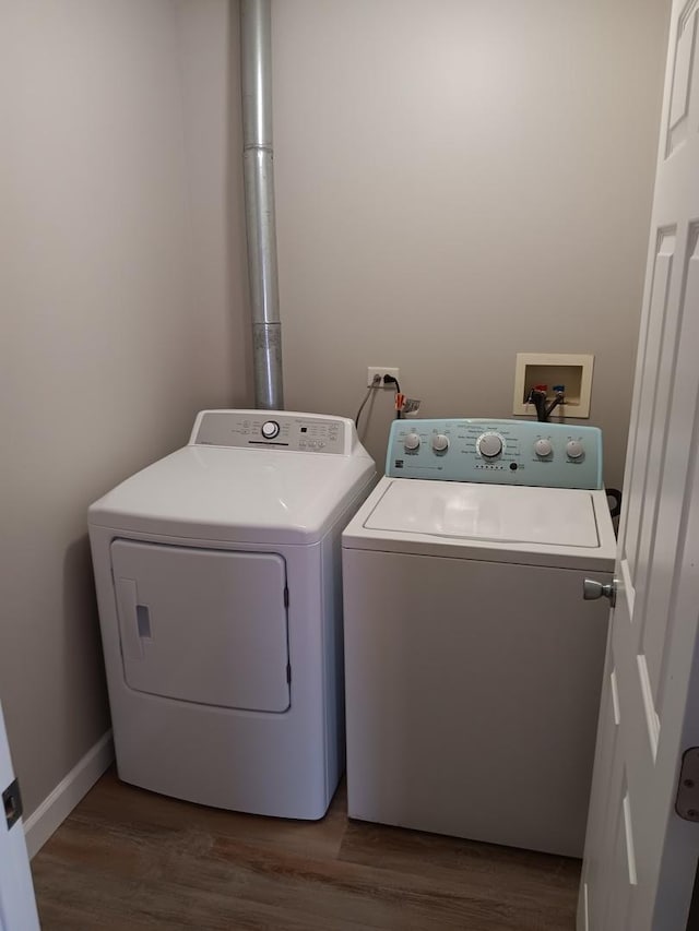 clothes washing area with dark wood-type flooring and washing machine and dryer