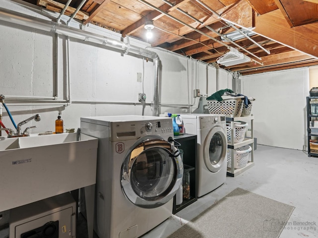 washroom with laundry area, a sink, and independent washer and dryer