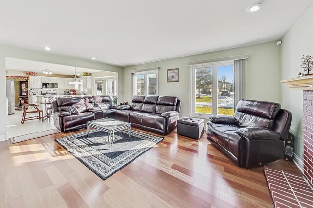 8431 Nielsen Dr, Tinley Park, IL 60487 - living room with an inviting chandelier, a fireplace, and light hardwood / wood-style flooring