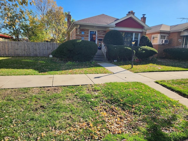 view of front of property with cooling unit and a front lawn