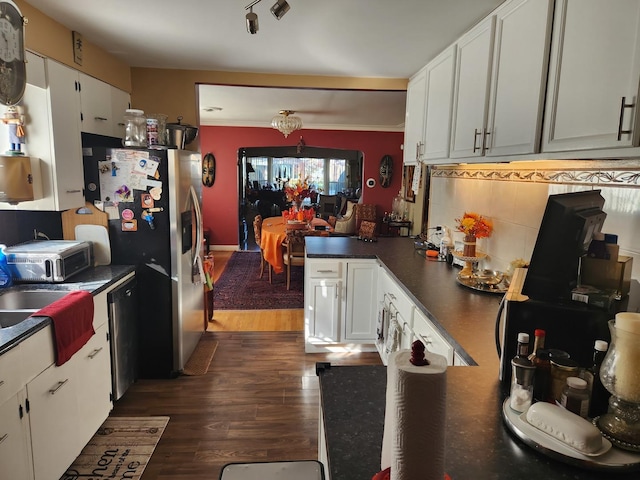 kitchen with white cabinetry, stainless steel appliances, dark hardwood / wood-style floors, and decorative backsplash