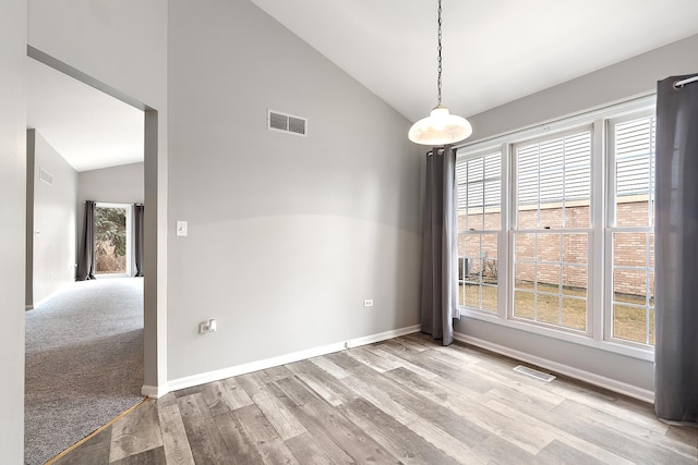 empty room featuring high vaulted ceiling and light hardwood / wood-style floors